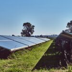 black solar panels on green grass field under blue sky during daytime